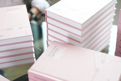 Several stacks of the finished hardcover, showing both the cover and spine, on a glass table